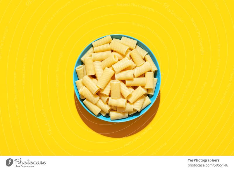 Rigatoni-Nudeln von oben auf einem gelben Hintergrund Schalen & Schüsseln hell Kohlenhydrate Farbe Essen zubereiten Textfreiraum kreativ Küche ausschneiden