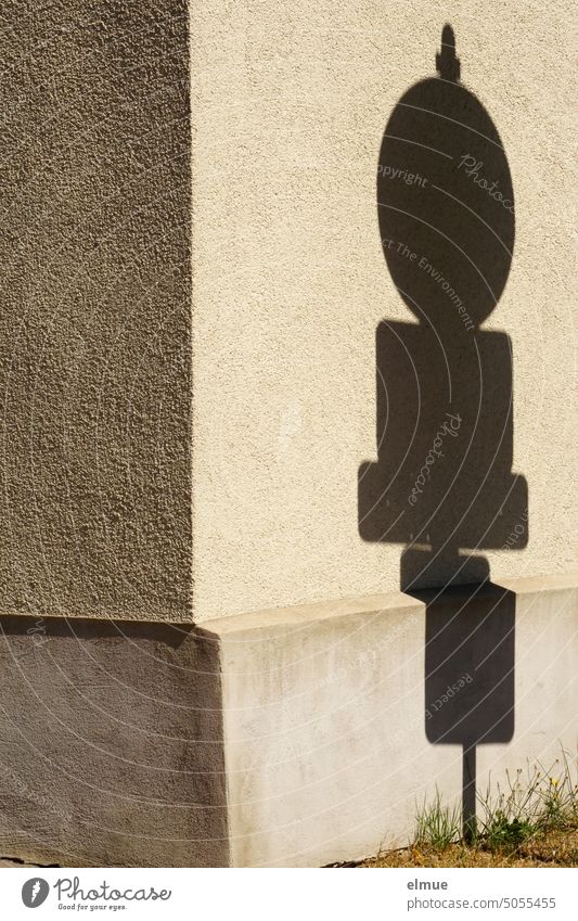 Schatten von mehreren Verkehrszeichen und Zusatzzeichen an einer Hausecke Verkehrsschild Zusatzschild Schattenspiel StVO Straßenverkehr Hinweisschilder Hauswand