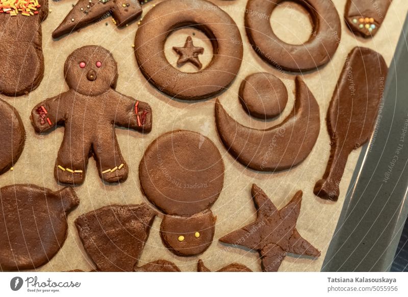 Draufsicht auf Ingwer-Weihnachtsplätzchen in verschiedenen Formen auf Pergament Lebkuchenplätzchen Cookies Süßigkeiten Keks Süße Lebensmittel Dessert