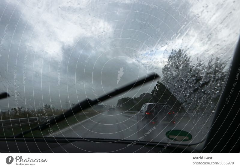 Ein Scheibenwischer bei Starkregen auf der Autobahn auto fahren autobahn scheibenwischer autoscheibe verkehr gefahr gefährlich risiko unfallgefahr nass straße
