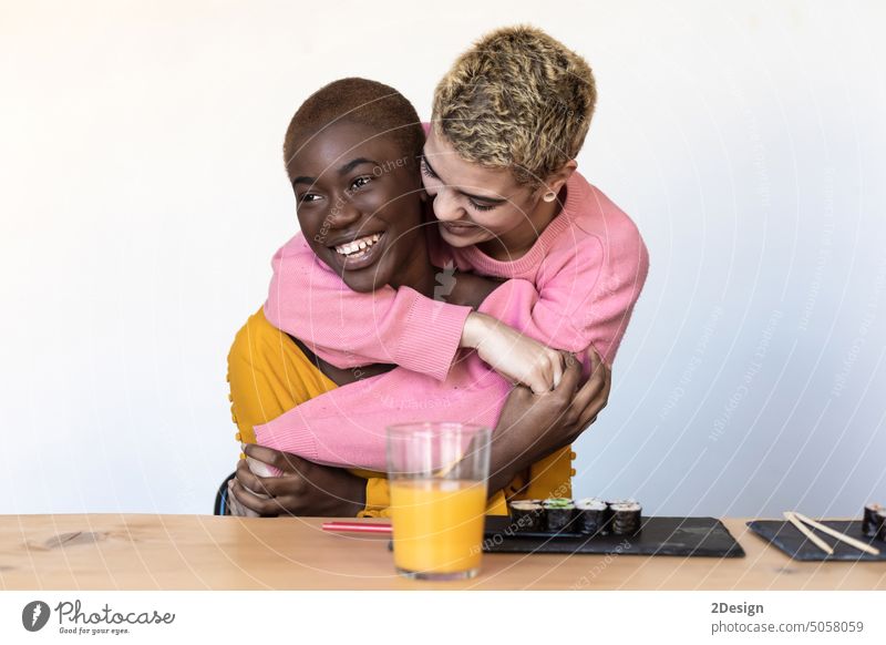 Eine junge Frau, die sich lachend und lächelnd eng umarmt, Zuneigung anhänglich Afrikanisch Afroamerikaner umarmend genießend Freund Freundschaft Freundin