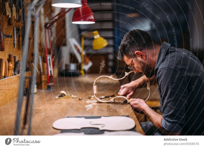 Geigenbauer bei der Herstellung von Geigenzargen in der Werkstatt Kunsthandwerker Kunstgewerbler Rippe Instrument Mann professionell Hobelbank Fähigkeit