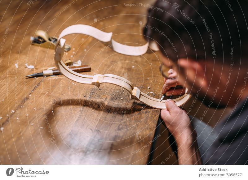 Anonymer Geigenbauer stellt in seiner Werkstatt Geigenzargen her Kunsthandwerker Kunstgewerbler Rippe Instrument Mann professionell Hobelbank Fähigkeit