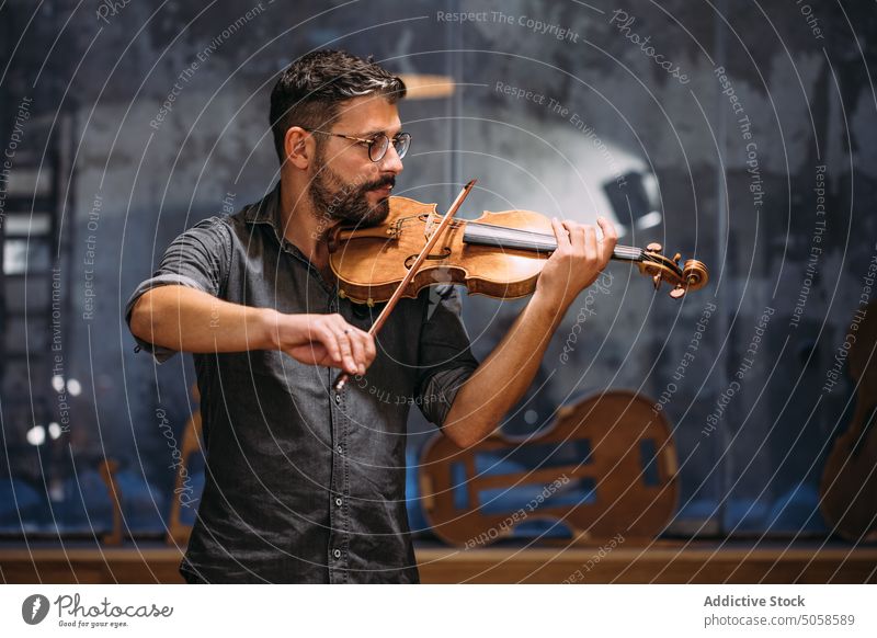 Geigenbauer spielt handgefertigte Geige Mann Zupfinstrumentenmacher spielen Kunsthandwerker Werkstatt prüfen Qualität Instrument Kunstgewerbler professionell