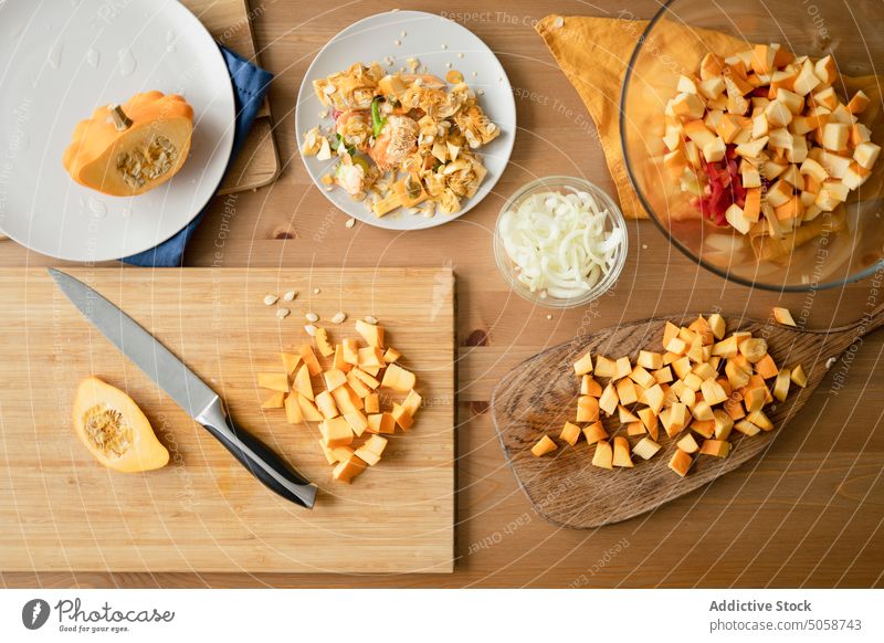 Geschnittenes Gemüse auf Holzbrett und Teller auf dem Tisch Squash Schneidebrett Küche Bestandteil Lebensmittel Kürbis sortiert appetitlich frisch vorbereiten