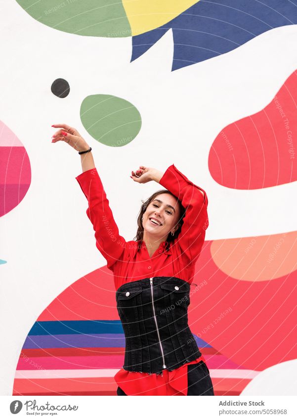 Glückliche Frau tanzt gegen bunte Wand Tanzen Straße farbenfroh Stil urban heiter modern Arme hochgezogen Individualität Gebäude sich[Akk] bewegen positiv hell