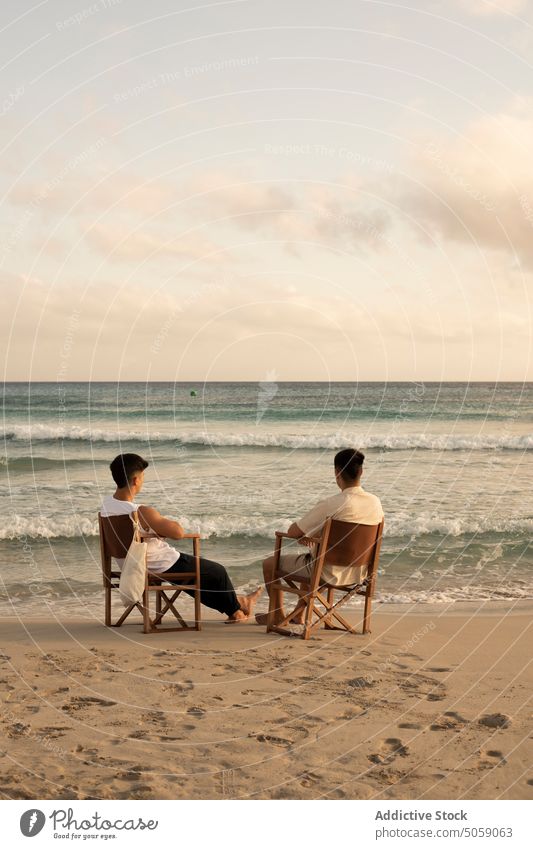 Anonyme Männer sitzen auf Stühlen am Meer Freund MEER Strand bewundern Natur endlos Urlaub wellig Zusammensein genießen Wasser Horizont Sommer Freundschaft