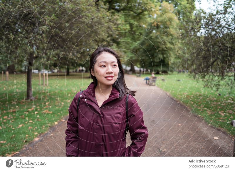 Asiatische Frau im Park stehend Herbst Wochenende Rasen Großstadt bewundern lässig warten London England vereinigtes königreich Großbritannien jung asiatisch