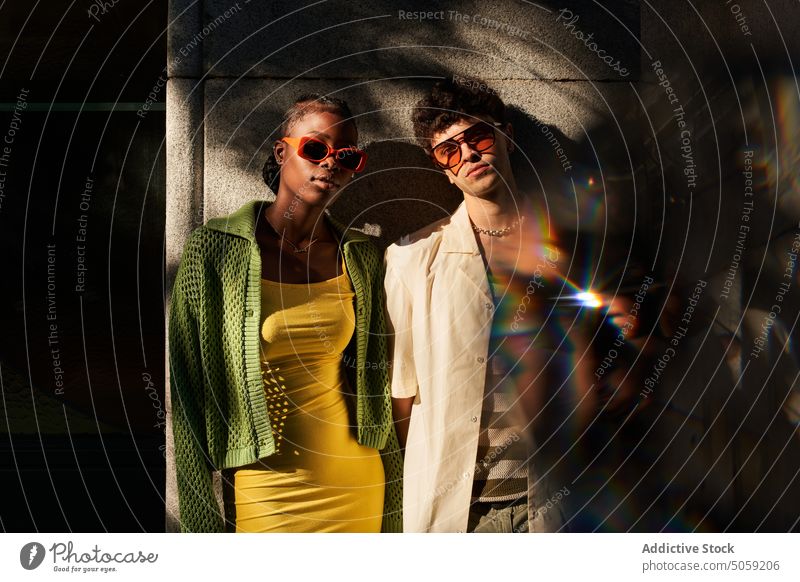 Trendiges junges multiethnisches Paar steht in der Nähe eines Gebäudes auf einer Straße in der Stadt Selfie Stil Zusammensein selbstbewusst Partnerschaft cool