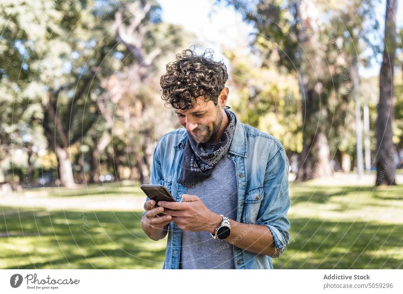 Mann durchsucht Smartphone im Park Browsen zuschauend Wochenende Sommer Rasen Telefonanruf tagsüber Gespräch männlich Anschluss lässig Mobile Apparatur Gerät