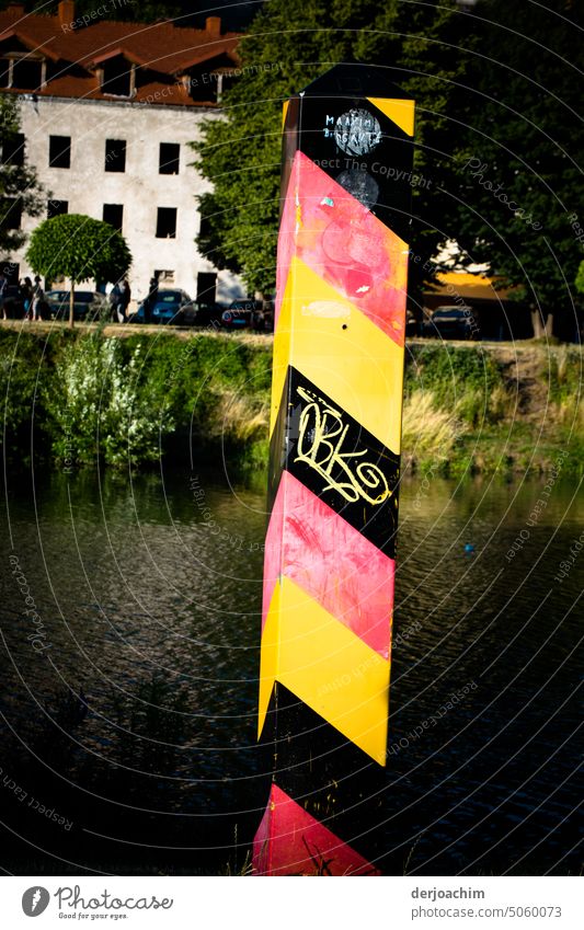 Grenz Pfosten Deutschland  - Polen am Fluss  in Görlitz  von Vandalismus beschmutzt. Wasser ruhig Außenaufnahme Tag Menschenleer Farbfoto Umwelt Gedeckte Farben