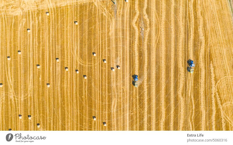 Luftaufnahme von Traktoren als gezogene Ballenmaschinen zum Einsammeln von Stroh vom abgeernteten Feld oben Antenne landwirtschaftlich Ackerbau Ballenpresse