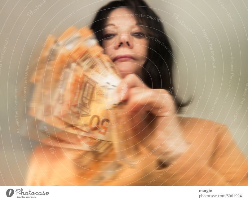Geldscheine entgleiten. Eine Frau hält viele Geldscheine in den Händen Frauengesicht Gesicht Erwachsene Euro 50 Euro 50 Euro Scheine Bargeld Einkommen Reichtum