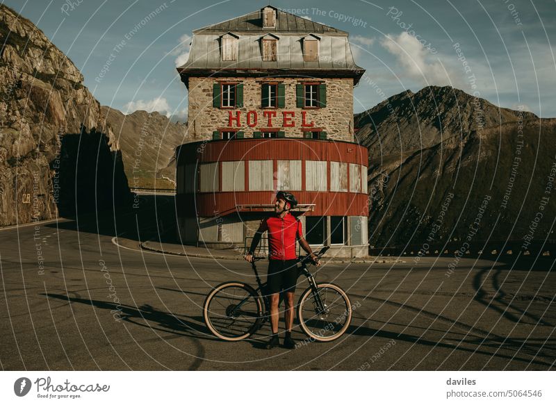 Porträt eines Radfahrers in der Mitte einer Kurve am Furkapass Alpen alpin Architektur Vollbart Belvedere Fahrrad Bikepacking binden Fahrradfahren furkapass