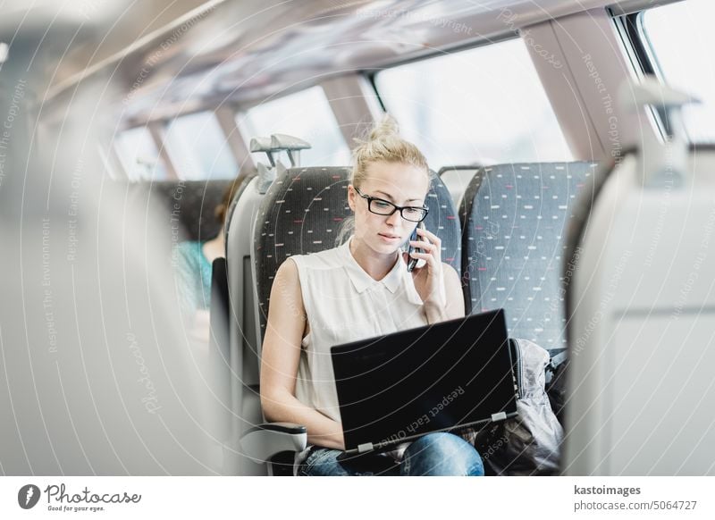 Geschäftsfrau bei der Arbeit, während sie mit dem Zug fährt. reisen reden Frau Telefon Laptop Verkehr Passagier Eisenbahn Reise Business Transport Smartphone