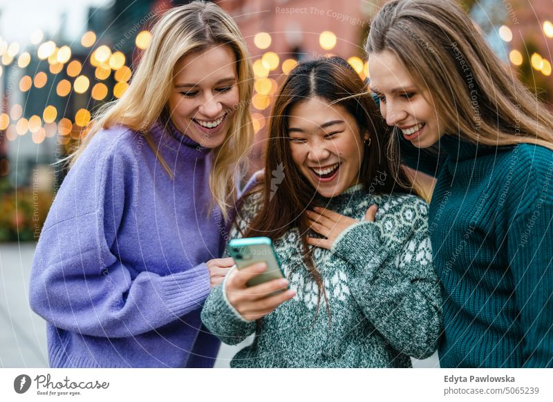 Gruppe von Freunden auf der Straße mit Smartphone echte Menschen offen Frau Mädchen jung Erwachsener Freundschaft Freundinnen Frauenpower Spaß Großstadt urban