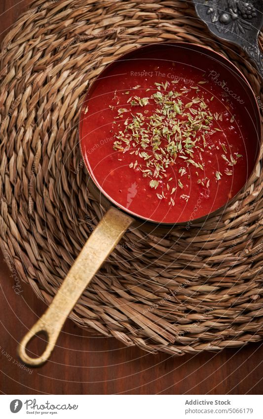 Kochtopf mit Tomatensauce auf gewebter Matte Saucen dienen Speise Unterlage Kraut Lebensmittel selbstgemacht kulinarisch Küche natürlich organisch Produkt