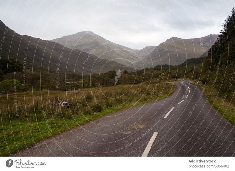 Kurvenreiche Straße im Tal in der Nähe der Berge Kamm Berge u. Gebirge grau wolkig Himmel Landschaft Schottland Schottisches Hochland Großbritannien