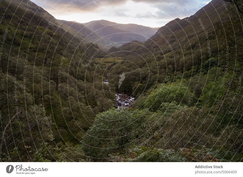 Bewölkter Sonnenuntergangshimmel über dem Tal Berge u. Gebirge Fluss wolkig Himmel üppig (Wuchs) Baum grün Abend Schottland Schottisches Hochland Großbritannien