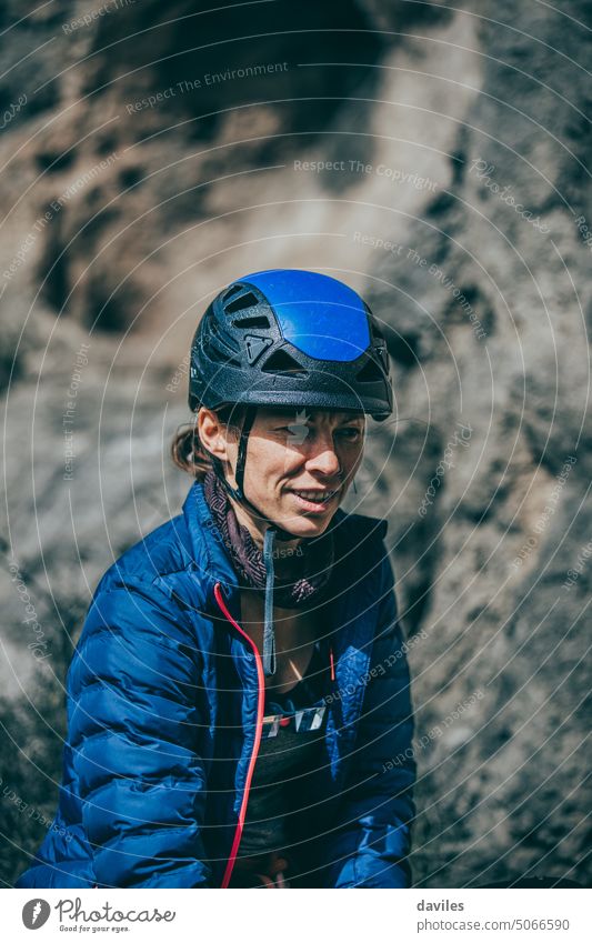 Bergsteigerin mit blauem Helm und Jacke während einer Pause zwischen zwei Klettertouren aktiv Aktivität Abenteuer Andalusia sportlich Österreicher Klippe
