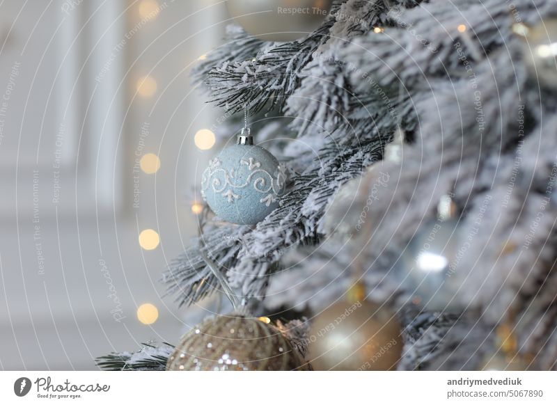 Der Weihnachtsbaum ist mit Schichten und Kunstschnee geschmückt. Feiertagshintergrund verschneite weihnachtsspielzeug Dekor Neujahr Weihnachten Zweig Kugel