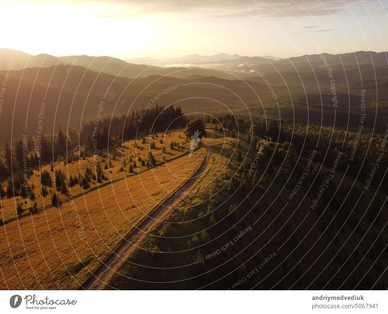 Luftaufnahme der schönen Bergkarpaten, Ukraine im Sonnenlicht. Drohne gefilmt eine Landschaft mit Nadel-und Buchenwälder, um eine kurvenreiche Serpentinenstraße, Kopter Luftaufnahme