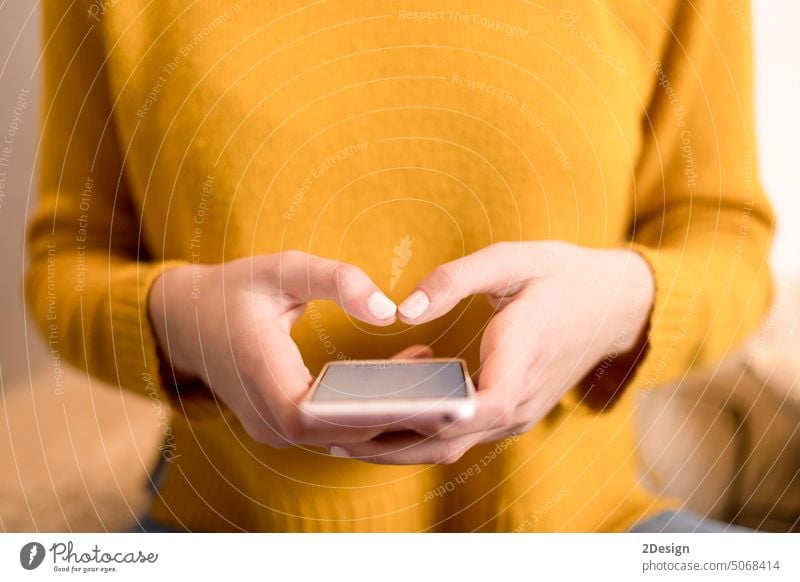 Nahaufnahme der Hand einer Frau im gelben Pullover, die ein Smartphone benutzt Person Technik & Technologie Tippen Mitteilung Telefon Lifestyle Mobile Business