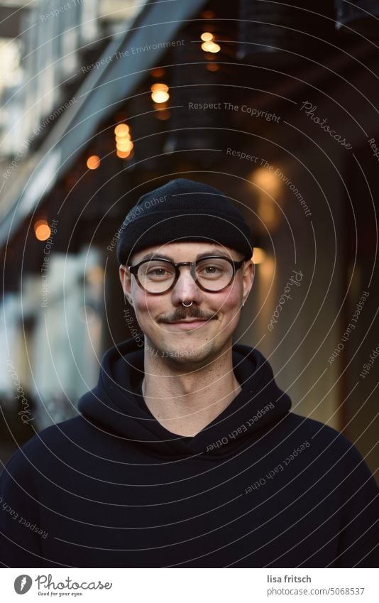 GRINSEN - MANN - BRILLE Mann Brille Nasenring Schnurrbart hoodie Mütze Lichterkette Coolness Erwachsene Bart Außenaufnahme Farbfoto Blick in die Kamera