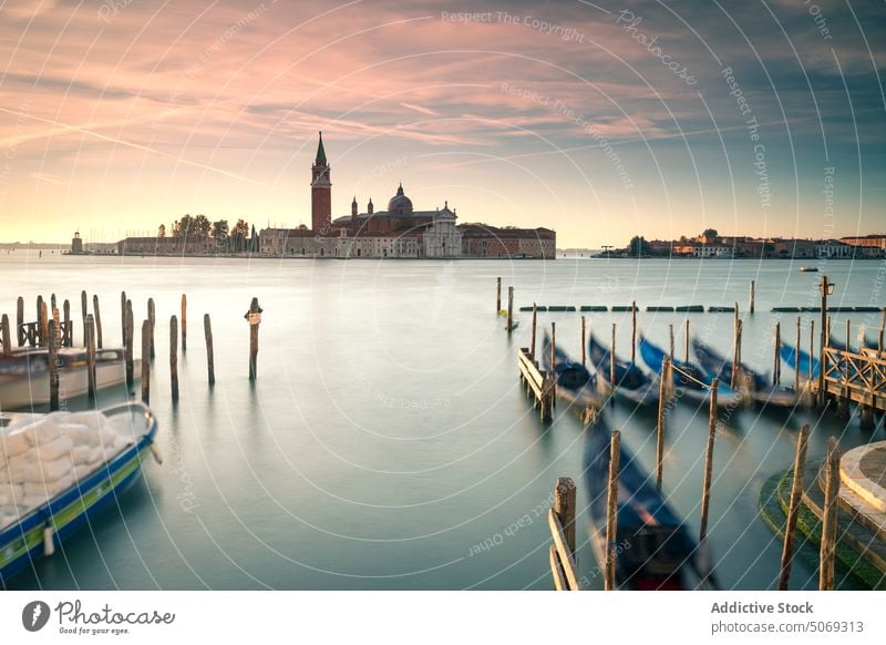 Gondeln auf dem Wasser in der Nähe der Insel mit Kirche Gondellift Sonnenuntergang Himmel wolkig Schwimmer reisen Abend Venedig Italien San Giorgio Maggiore