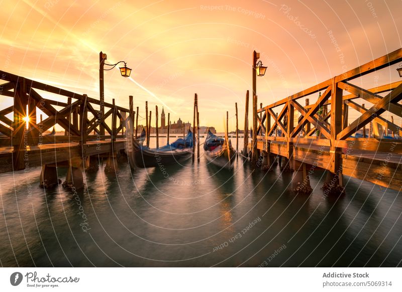 Gondeln in der Nähe der Piers bei Sonnenuntergang Gondellift Maure Himmel wolkig Tradition Abend Kanal Wasser Venedig Italien San-Marco-Becken Boot Verkehr