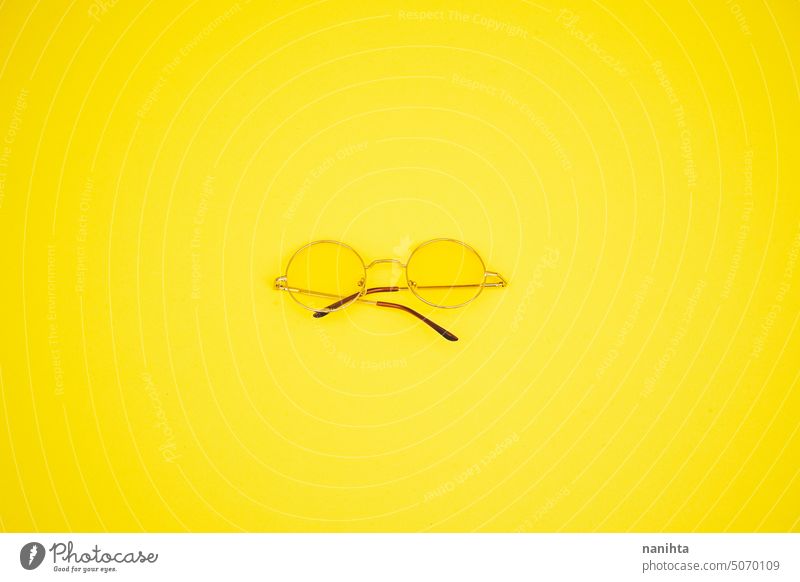 Minimal Bild der retro gelbe Sonnenbrille gegen gelben Hintergrund minimalistisch Mode Brille sehr wenige Textfreiraum Kopie Raum negativ altehrwürdig Monochrom