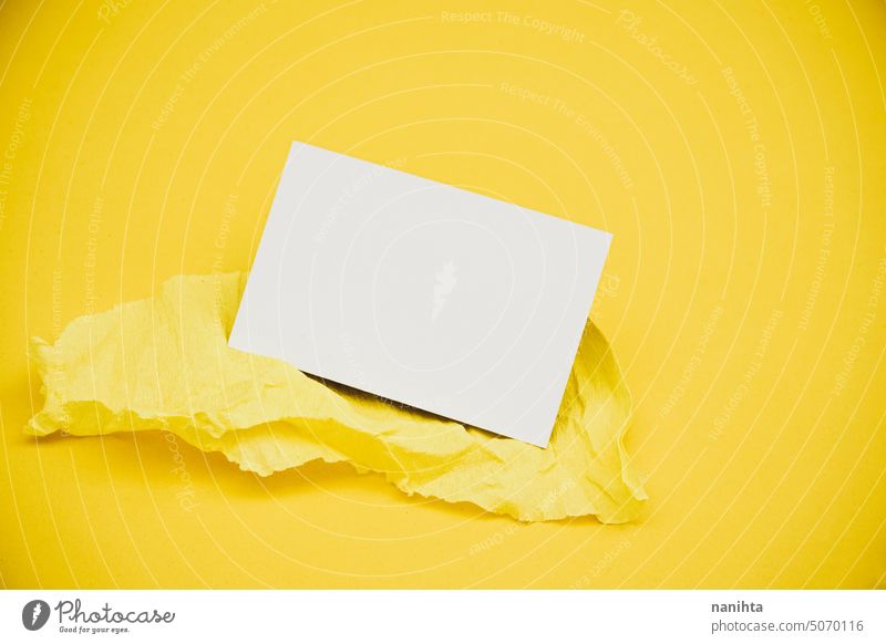 Blanko-Visitenkarte über einem gelben Krepppapier vor gelbem Hintergrund Attrappe blanko Postkarte Business Flachlegung sehr wenige minimalistisch Mode Papier