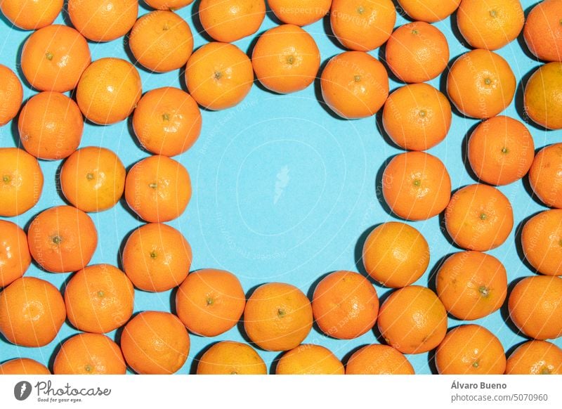 Saftige und natürliche Mandarinen-Textur mit Leerraum in der Mitte Früchte Vitamin C Hintergrund blau unordentlich kreisen im Inneren leer regelwidrig Konzept