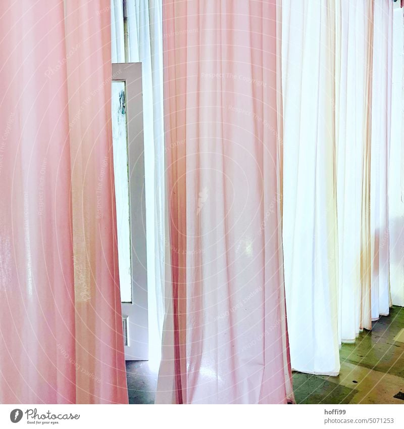 rosa und weiß beleuchtete Vorhänge einer Umkleide Anprobe Kabine mit leicht geöffnetem mysitriösem Fensterflügel Vorhang Beleuchtet Gardine Stoff Licht