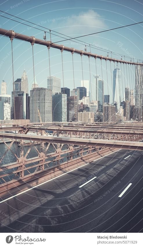 Retro-Tonbild von New Yorker Stadtbild durch Brooklyn Bridge Kabel gesehen, USA. New York State Wolkenkratzer retro Büro Skyline Straße Manhattan Großstadt