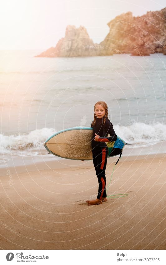 Kleiner Surfer mit Surfbrett Surfen Kind Sonnenuntergang horizontal winken Sand Sport blond Abenteuer Strand im Freien MEER Sommer reisen Freiheit Freude
