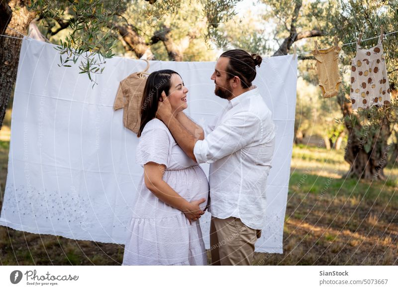 Glückliches junges Paar, das ein Baby erwartet. Schwangerschaft und Elternschaft Konzept. Frau Mann schwanger Fotografie im Freien Kaukasier Familie