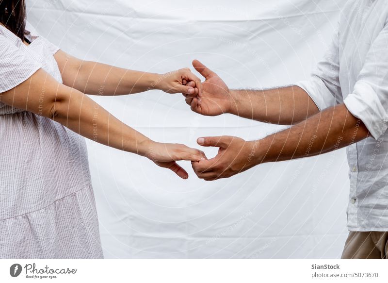 Schwangere Frau und ihr Mann berühren sich gegenseitig die Finger Paar Hände romantisch schwanger Schwangerschaft Bauch im Freien Glück Konzept Kaukasier