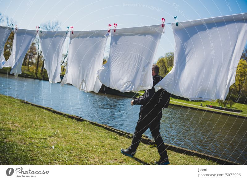 Der luftige Weg durch frische Wäsche Wäscheleine Bekleidung T-Shirt Sauberkeit sauber trocknen hängen Wind Haushalt Kleidung Fluss Flussufer Wäscheklammern