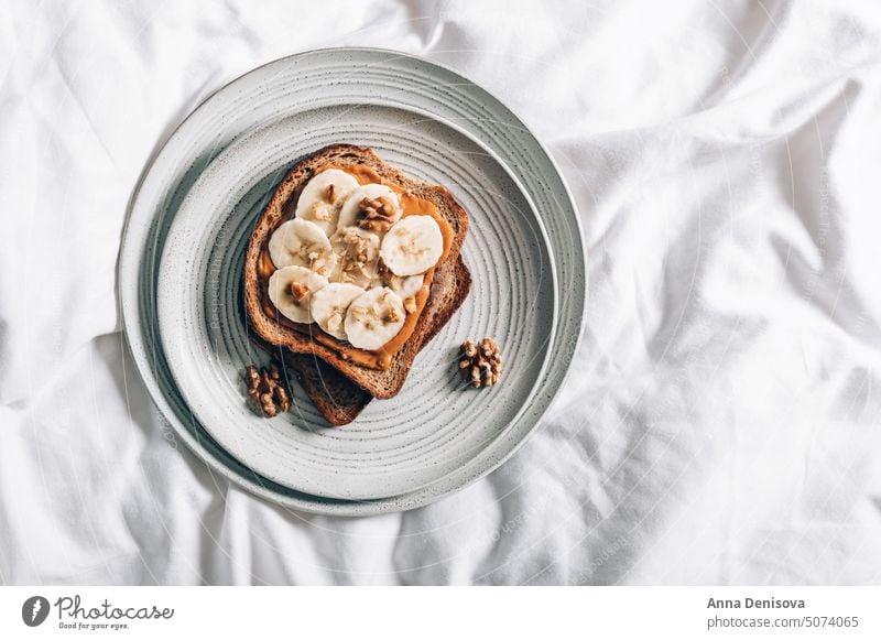Gesundes offenes Sandwich mit Erdnussbutter Belegtes Brot Nussbutter Gesundheit Banane Snack Frühstück im Bett Mandel Cashewnuss Katze Katzenbaby Vollkornbrot