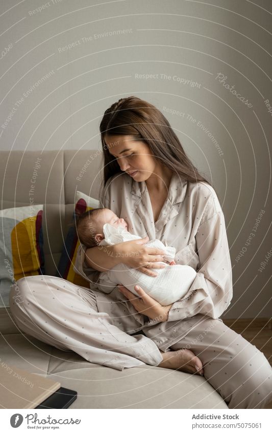 Junge Mutter streichelt schlafenden Säugling Baby Umarmung Streicheln Sofa Wohnzimmer heimwärts Liebe Morgen Frau jung Angebot friedlich Pyjama Zuneigung Eltern