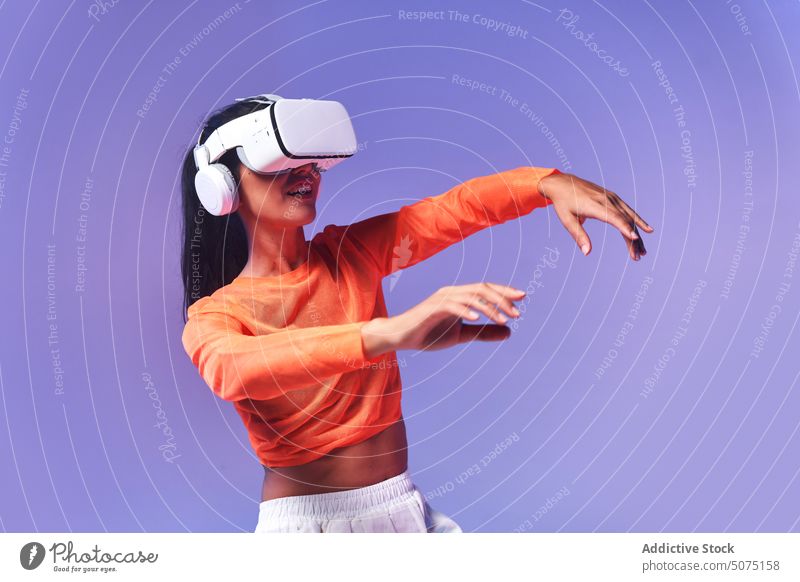 Glückliche Frau tanzt in der virtuellen Realität Tanzen VR erkunden Lächeln Erfahrung Stil Headset farbenfroh hell ausdehnen Virtuelle Realität Schutzbrille