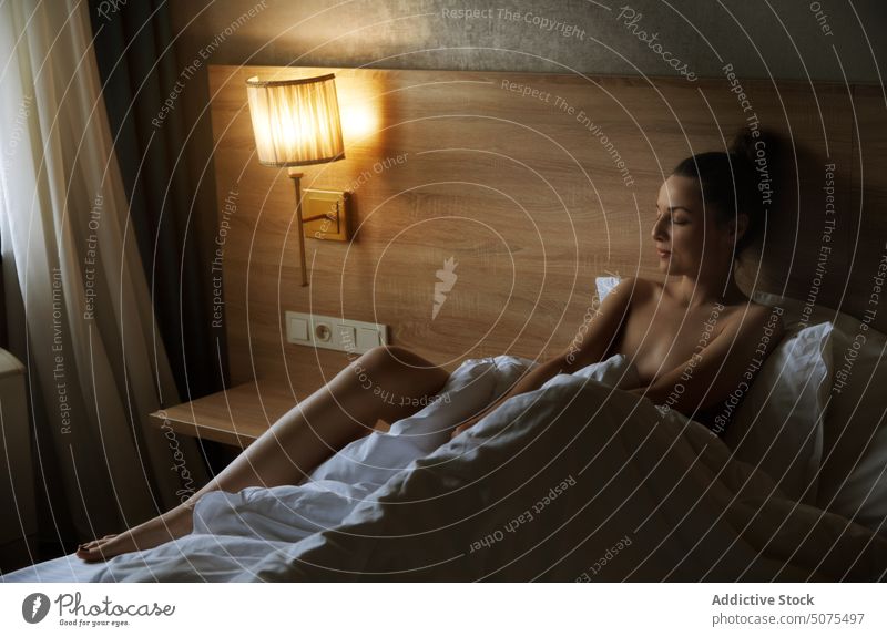 Glückliche Frau entspannt auf einem Bett in gemütlichem Interieur Schlafzimmer Sinnlichkeit Schönheit Erholung aussruhen bequem Leinen Schlafenszeit Kopfkissen