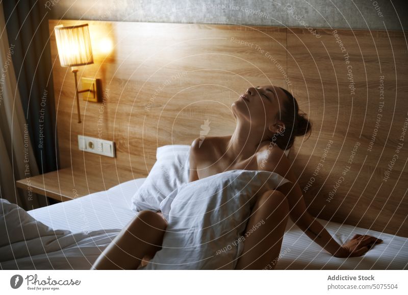 Frau entspannt und auf dem Bett in einem gemütlichen Interieur Schlafzimmer Sitzen menschlicher Körper Sinnlichkeit Schönheit Erholung aussruhen bequem Leinen