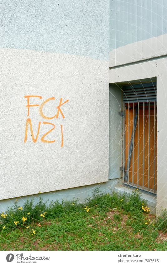 Schriftzug FCK NZI an einer Hauswand Graffiti Meinung FCK NZS fuck nazis Gebäude Demonstration Politik & Staat Schriftzeichen Außenaufnahme Farbfoto Wand