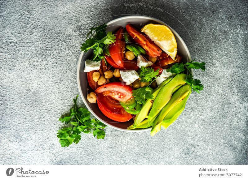 Gesunder Salat mit Bio-Gemüse Avocado Hintergrund Schalen & Schüsseln Käse Beton Koriander Salatgurke Besteck Diät essen Kichererbsen Essen Feta Lebensmittel