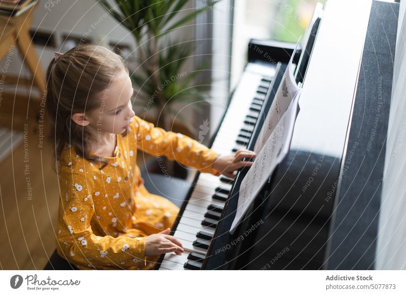 Kleines blondes Mädchen übt Musik mit dem Klavier Kind Lernen Person Musiker Pianist Kindheit Bildung üben Instrument praktizieren Klassik im Innenbereich