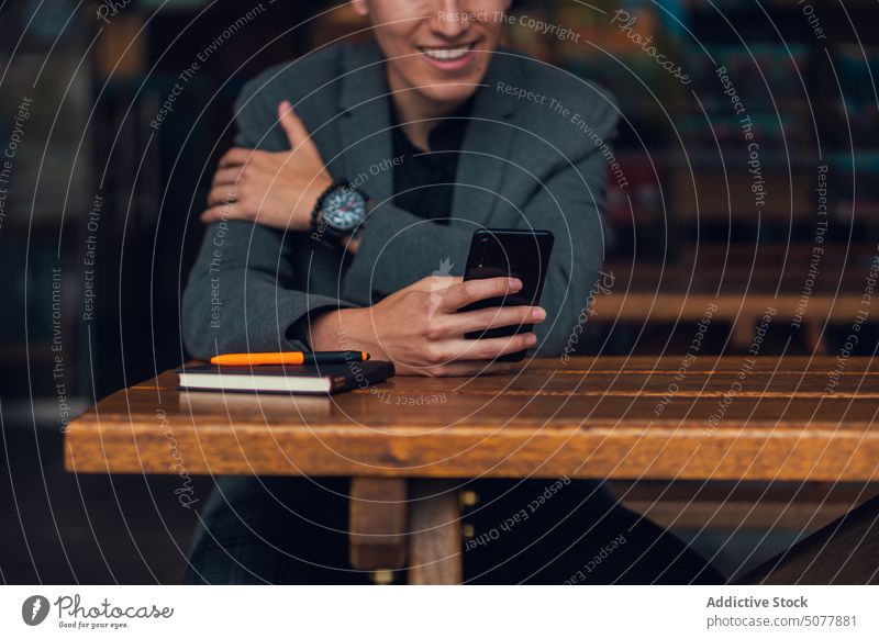Konzentrierter Mann mit Smartphone im Café benutzend Talkrunde Notebook ruhen Kantine Plan Surfen Internet Fokus Geschäftsmann formal stilvoll Business