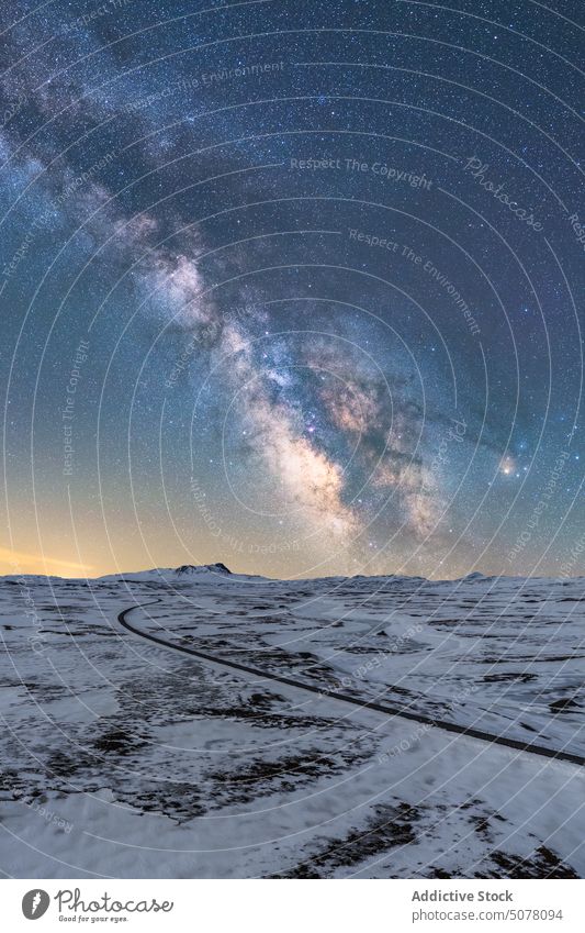 Lange Asphaltstraße, umgeben von Schnee und Eis bei Nacht in Island Straße Nationalpark Vatnajokull Frost Galaxie funkeln endlos Land eng Natur kalt Regie stumm