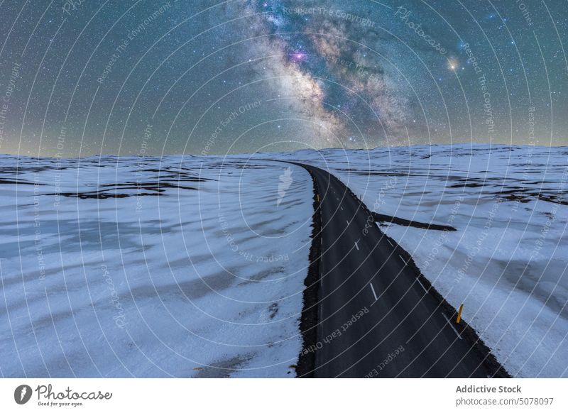Lange Asphaltstraße, umgeben von Schnee und Eis bei Nacht in Island Straße Nationalpark Vatnajokull Frost Galaxie funkeln endlos Land eng Natur kalt Regie stumm